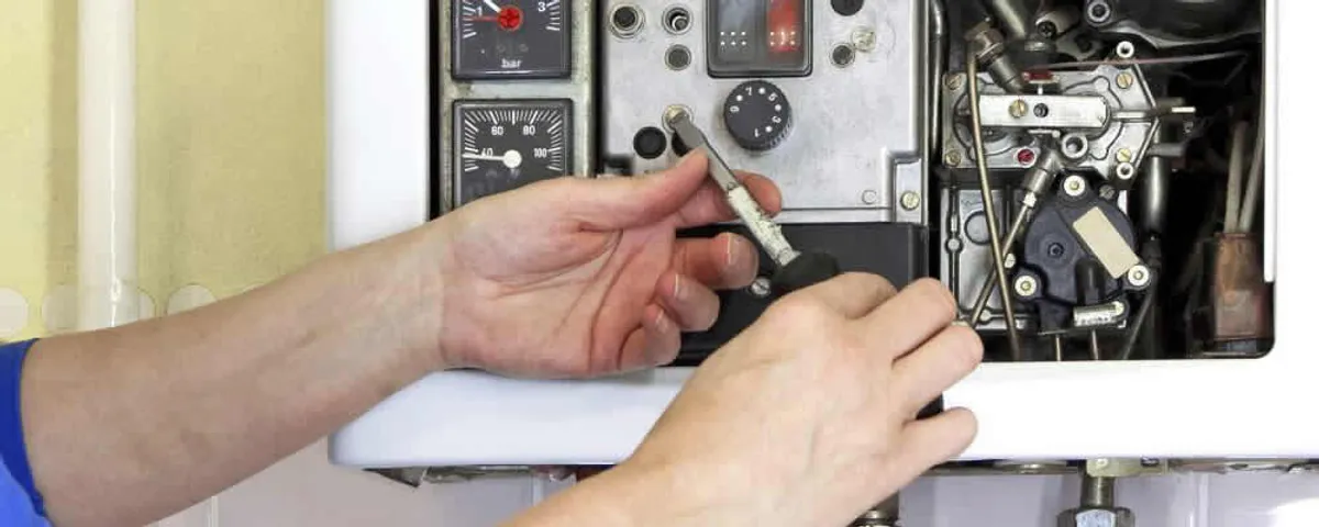 Heating repair technician adjusting boiler controls and components in Loveland, CO