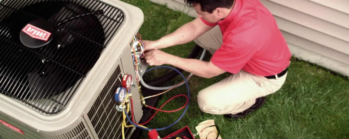 HVAC technician servicing an outdoor air conditioner unit in Loveland, CO